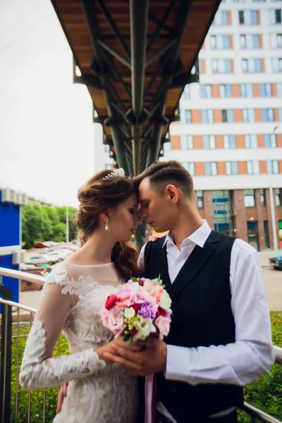 Noiva e noivo andando na cidade, dia do casamento, conceito de casamento. Noiva e noivo em fundo urbano. jovem casal indo em uma escada no dia do casamento . — Fotografia de Stock