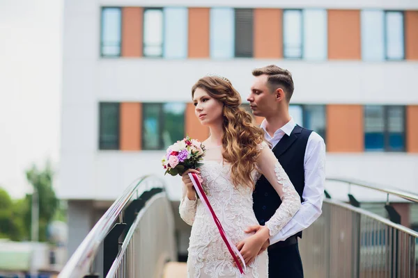 Novia y novio caminando por la ciudad, día de la boda, concepto de matrimonio. Novia y novio en el fondo urbano. joven pareja yendo en un escaleras en boda día . —  Fotos de Stock