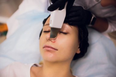 Kozmetik ofiste profesyonel ültrasyon cihazları ile temizlik tedavi alan kadın