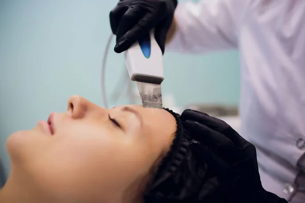 Женщина, получающая очищающую терапию с помощью профессионального ультразвукового оборудования в косметологическом кабинете — стоковое фото