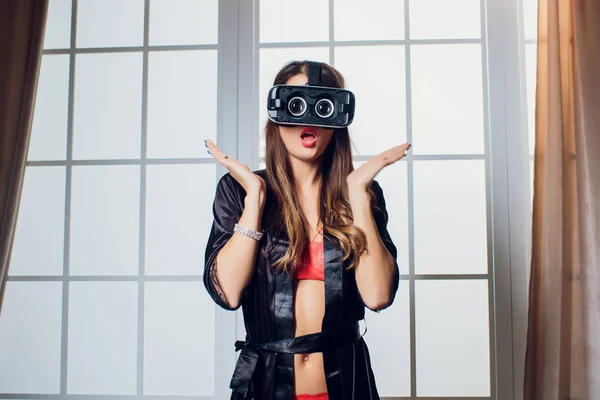Beautiful woman wearing Lingerie using vr-goggles in bed. — Stock Photo, Image