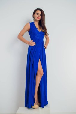 mavi elbiseli poz esmer güzel ve genç birbayan. Glamour makyaj. Uzun saçlı. Stüdyo vurdu.