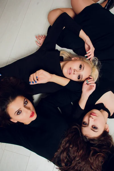 Tres amigas con ventosas sonriendo mienten . — Foto de Stock