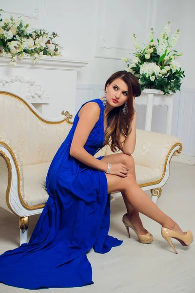 Brunett vacker ung kvinna poserar i blå klänning. Glamour makeup. Långt hår. Studio skott. — Stockfoto