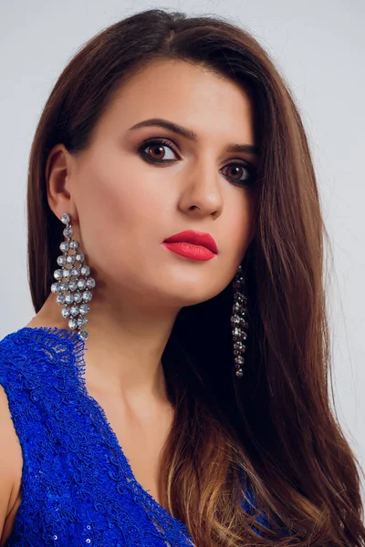 Brunette mooie jonge vrouw poseren in blauwe jurk. Glamour make-up. Lange haren. Studio schoot. — Stockfoto