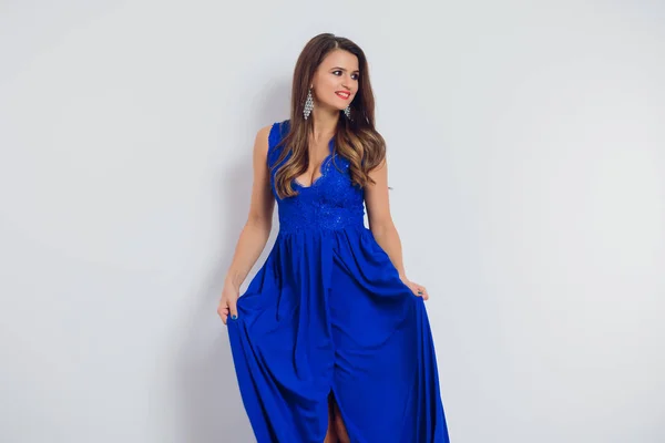 Brünette schöne junge Frau posiert in blauem Kleid. Glamour-Make-up. lange Haare. Studioaufnahme. — Stockfoto