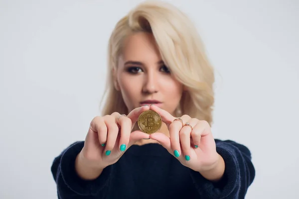 Retrato de una joven mujer de negocios rubia con una camisa negra, bitcoin . — Foto de Stock