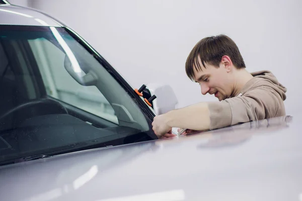 Werknemer handen installeert auto verf bescherming film. — Stockfoto