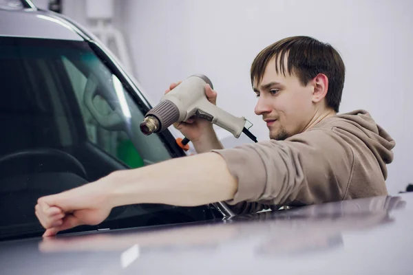 Werknemer handen installeert auto verf bescherming film. — Stockfoto