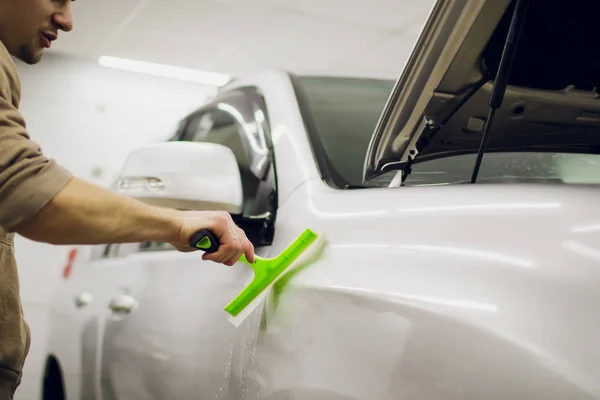 Mani lavoratore installa pellicola di protezione vernice auto . — Foto Stock