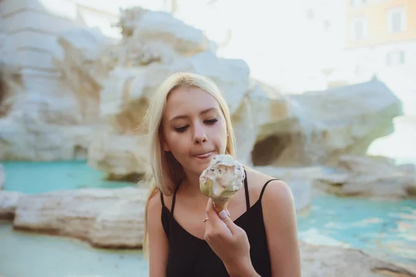 Gelato, giovane bella ragazza bionda in un abito luminoso ottiene piacere dal gelato. Sa di eschimese giallo. Mi diverto. In casa. Fondo bianco . — Foto Stock