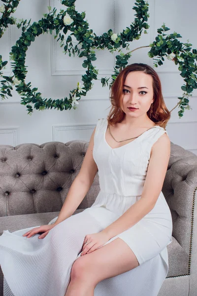 Joven modelo femenino hermoso en vestido blanco sobre fondo blanco estudio mujer morena pelo maquillaje cuerpo forma ropa colección verano oficina estilo casual fiesta todos los días moda . —  Fotos de Stock