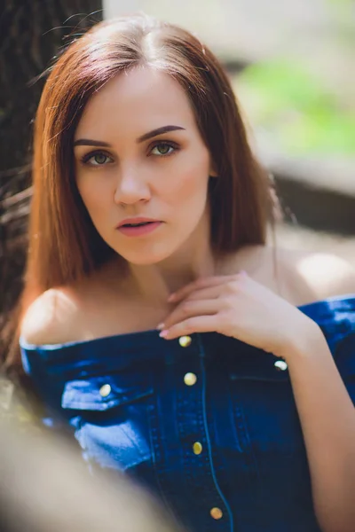 숲에서 자연 백그라운드에 카메라 앞에서 포즈를 취하는 파란 드레스에 아름 다운 젊은 여자. — 스톡 사진