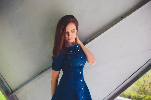 Zeer mooie jonge brunette vrouw draagt een blauwe jurk in de straat. — Stockfoto