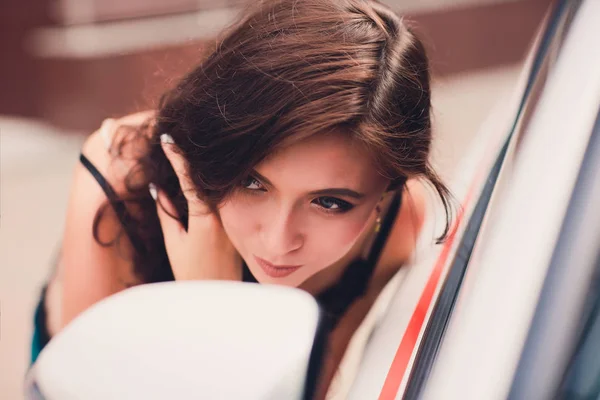 Lachende vrouw komt tot uiting in de spiegel van de auto. — Stockfoto