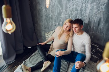 Hamile eşi oturan ve elini tutarak bebek orta yaşlı bir adam için bekliyor