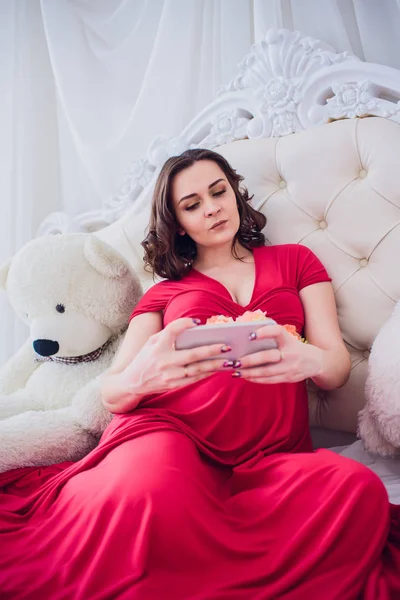 Happy usmívající se těhotná žena seděla na trávě a dělá autoportrét na smartphone. těhotná žena dělá selfie. — Stock fotografie
