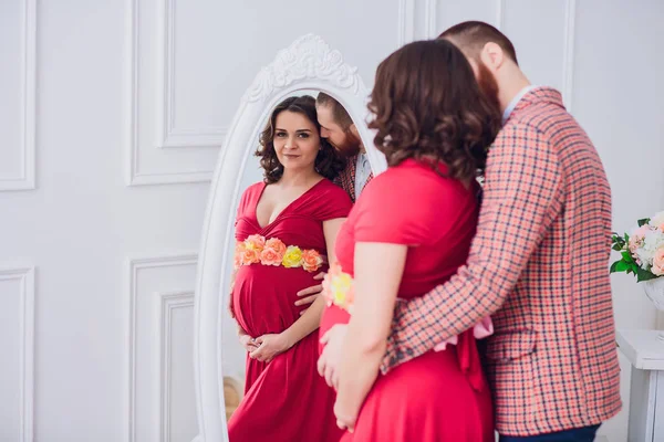 Foto di Felice futuro padre guardare la moglie incinta. marito e incinta su uno sfondo specchio . — Foto Stock