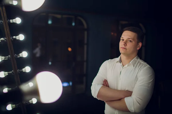 Elegant handsome young man sitting by fireplace in room with classic vintage interior. Fashion shot. — Stock Photo, Image