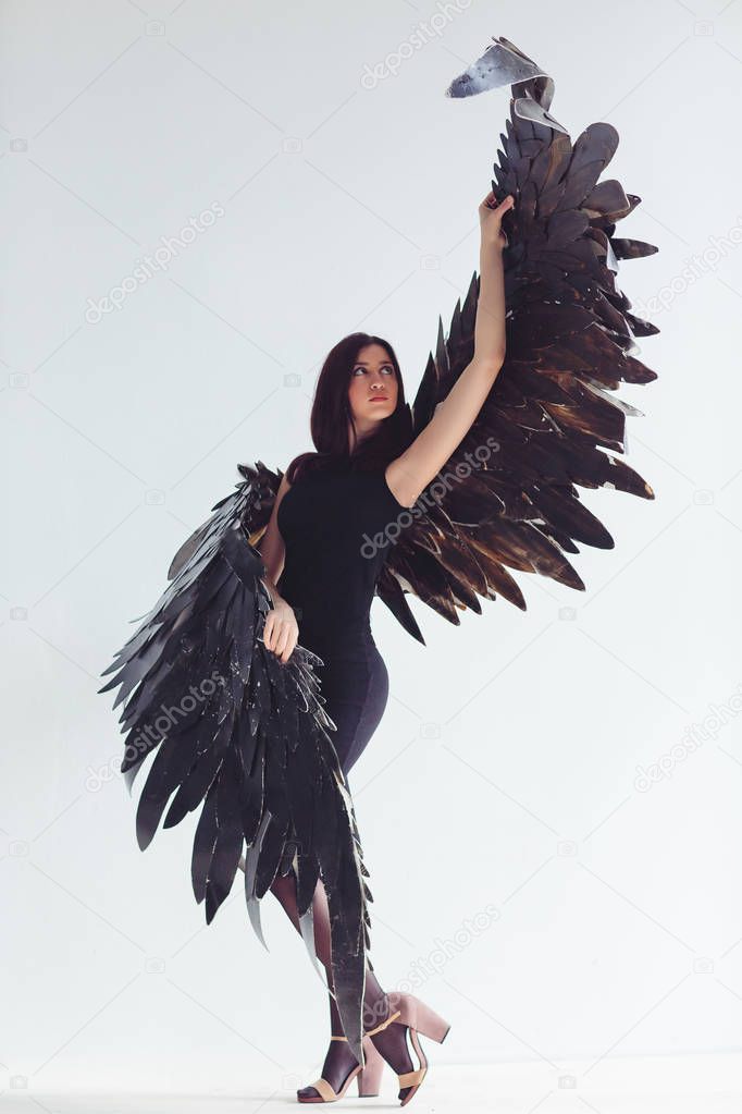 Fallen black angel with wings. Sexual woman.