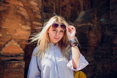 arka plan Tapınağı karşı mavi elbise içinde genç kız duvar içinde güneş gözlüğü. Anlayışı Modern din