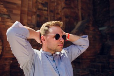 adam arka plan Tapınağı karşı mavi elbise içinde duvar içinde güneş gözlüğü. Modern din anlayışı