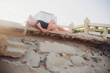 güzel sarışın kız siyah gövde üzerinde harap Vietnamca merdiven yatıyor