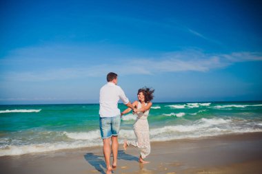 Mutlu balayı tatil cenneti. Çift plaj beyaz kum üzerinde rahatla. Mutlu deniz yaşam tarzı. Genç Aile, erkek ve kadın okyanus plaj üzerinde bekletin. Aşık çift adaya seyahat. Aşk seyahat