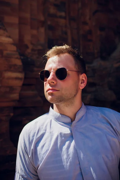 Man in blue robe against background temple wall in sunglasses. CONCEPTION OF MODERN RELIGION — Stock Photo, Image