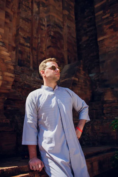Ember a kék köpenyt viselt ellen háttér templom fali napszemüveg. Koncepció a Modern vallás — Stock Fotó