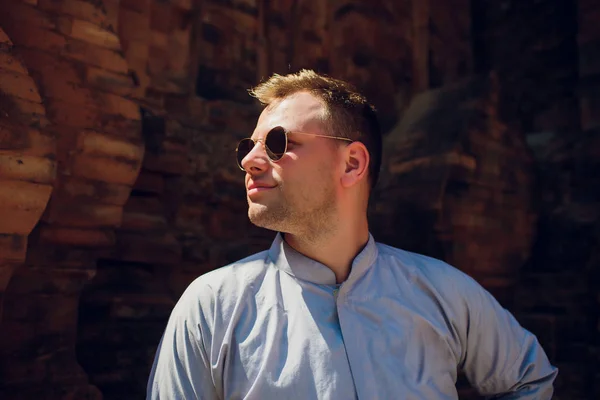 Man in blue robe against background temple wall in sunglasses. CONCEPTION OF MODERN RELIGION — Stock Photo, Image