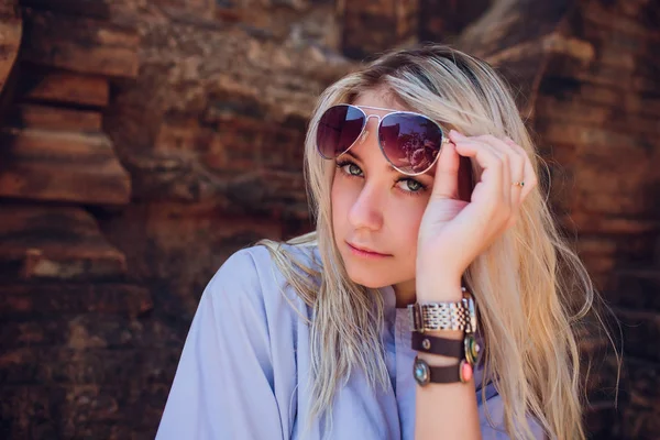 Jovem menina em roupão azul contra parede do templo de fundo em óculos de sol. RELIGIÃO MODERNA DE CONCEPÇÃO — Fotografia de Stock