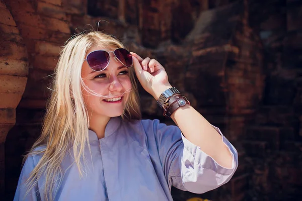 Jovem menina em roupão azul contra parede do templo de fundo em óculos de sol. RELIGIÃO MODERNA DE CONCEPÇÃO — Fotografia de Stock