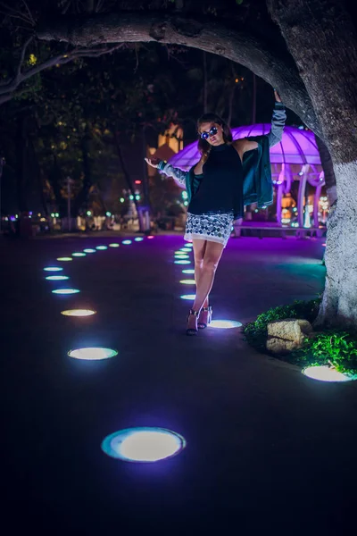 Hermosa chica en un fondo de iluminación nocturna en asia — Foto de Stock