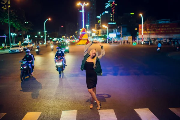 Nha Trang, Vietnam - Únor 17,2018: krásná blondýnka na pozadí noci na silnici v Asii — Stock fotografie