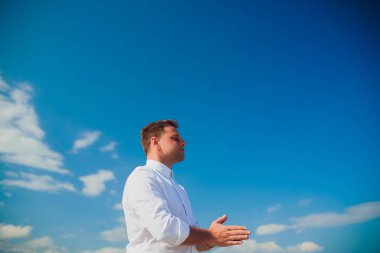 Yakışıklı adam beyaz kıyafetlerle deniz sahne poz