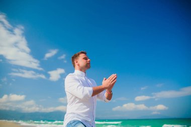 Deniz sahne poz beyaz kıyafetlerle yakışıklı erkek