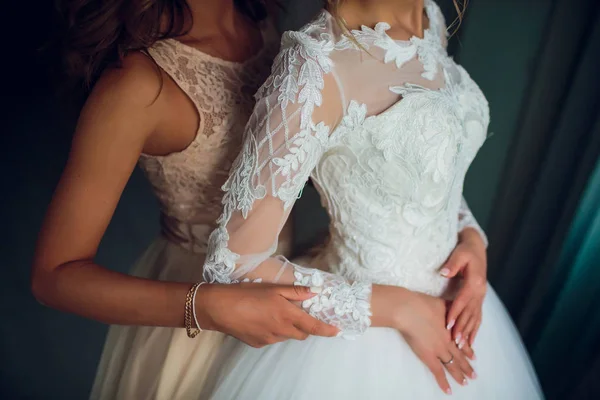 Duas noivas estão sussurrando sobre algo e rindo. Meninas delicadas bonitas em vestidos de noiva . — Fotografia de Stock