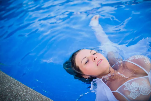 Fürdőköntös, relaxációs medence, a spa resort egy nő a medence a gyönyörű fiatal nő portréja úszik — Stock Fotó