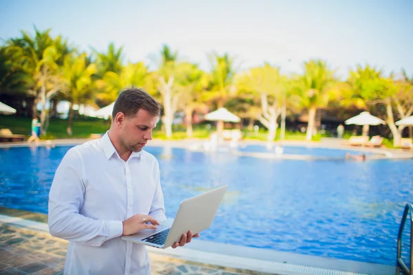 Working on laptop from the swimming pool — Stock Photo, Image