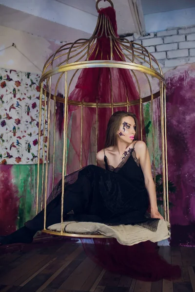 Fashion model in fantasy dress posing steel cage — Stock Photo, Image