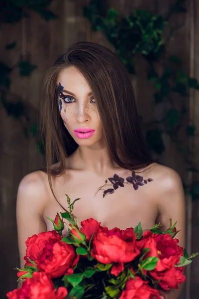 Giovane bella bella ragazza in piedi e in possesso di scatola con rose rosse. Vogue stile studio ritratto ragazza in abito elegante nero in piedi — Foto Stock