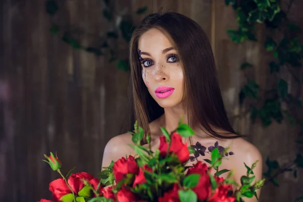 Όμορφη όμορφη κοπέλα στέκεται και κρατώντας κουτί με κόκκινα τριαντάφυλλα. Vogue μόδας στυλ στούντιο πορτρέτο κορίτσι σε μαύρο κομψό φόρεμα στέκεται — Φωτογραφία Αρχείου