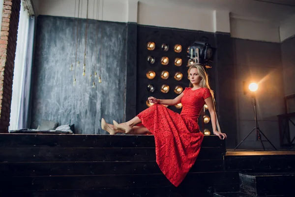 Vacaciones y concepto de moda - hermosa mujer sexy en vestido rojo sobre fondo de luces — Foto de Stock