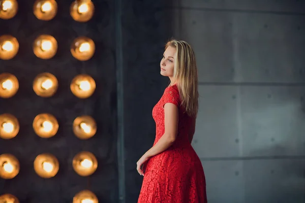 Vacaciones y concepto de moda - hermosa mujer sexy en vestido rojo sobre fondo de luces — Foto de Stock