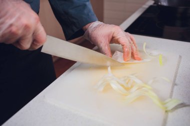 el tutma bıçak üzerinde plastik kesme tahtası hazırla aşçı mutfak için beyaz yeşil lahana kesmek