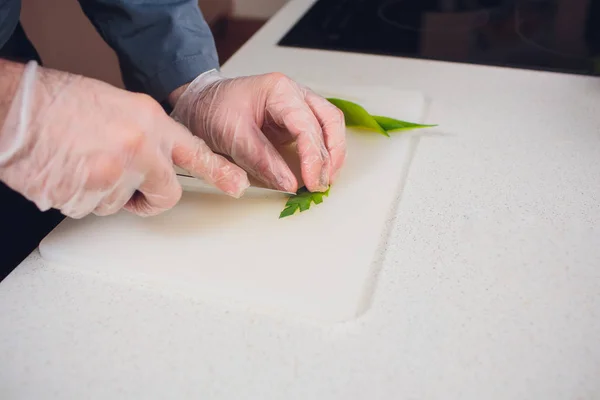 家庭主妇在厨房里切芹菜厨师。把刀切碎在切碎的木板背景上用刀切芹菜。烹饪厨房的概念. — 图库照片