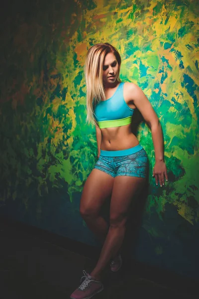 İnce yapılı sportif kadının yatay atış rahat top ve şort giymiş güzel sağlıklı kas vücut vardır. Atletik kız ara egzersiz yaptıktan sonra verirler..