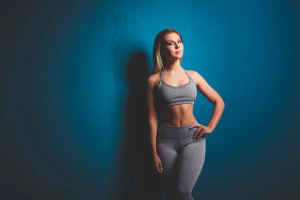 Tiro horizontal de mujer delgada deportiva tiene un cuerpo muscular saludable agradable, vestido con top casual y pantalones cortos. Atlética chica toma descanso después del entrenamiento . — Foto de Stock