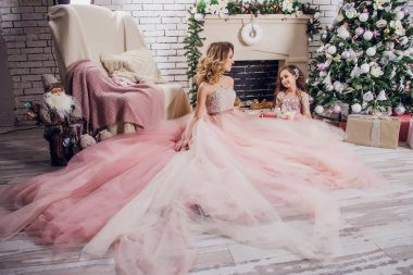 Bayram, kutlama ve insanlar kavramı - Noel iç arka plan üzerinde şık elbiseli Genç kadın. Tahıl anne ve kızı ile görüntü